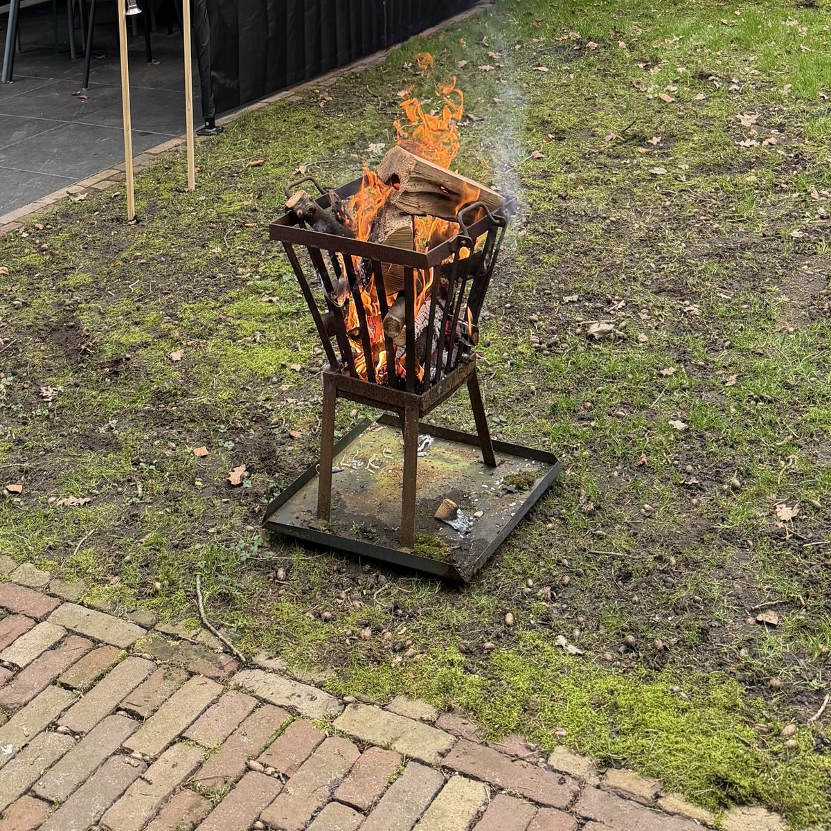 Vuurkorf met brandend hout op locatie
